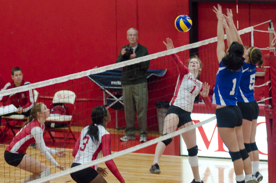 Catherine Amyot rises to spike ball past a Carabins block. (Jesse Conterato / McGill Tribune)