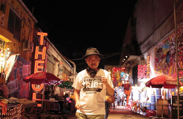 Director Sion Sono stands in the streets of Tokyo