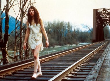 girl walks along railroad