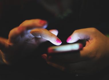 woman holding cellphone in the dim room