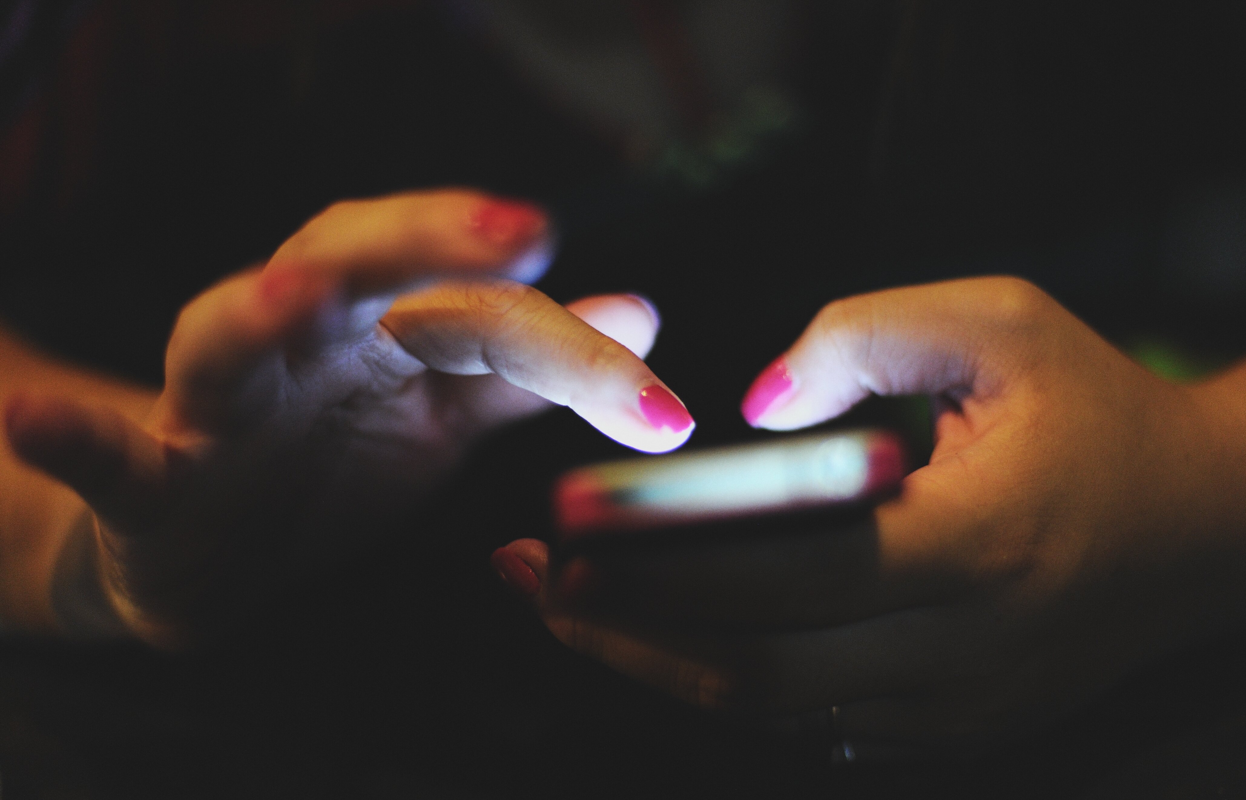 woman holding cellphone in the dim room